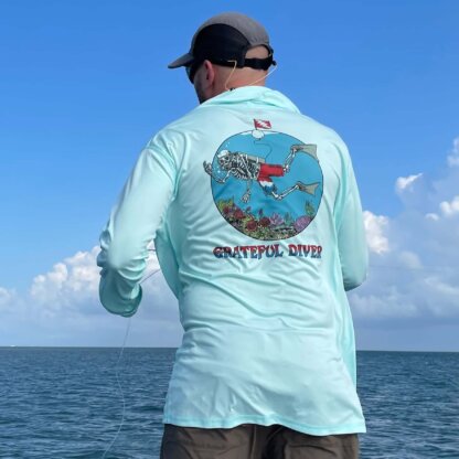 A man wearing the Grateful Diver Skeleton Diver UPF 50+ Hoodie on a boat, fishing in the ocean.