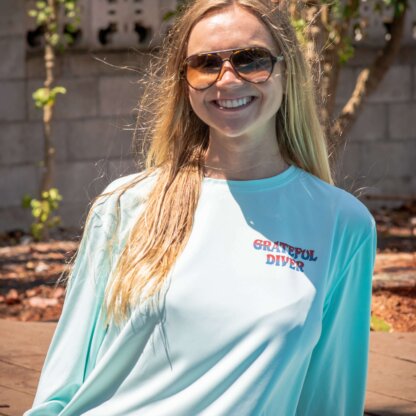 A woman wearing sunglasses and a Grateful Diver Sugar Skull UV Shirt.
