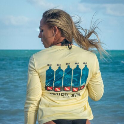 Grateful Diver Dive Tanks UV Shirt in pale yellow on model back shot at ocean