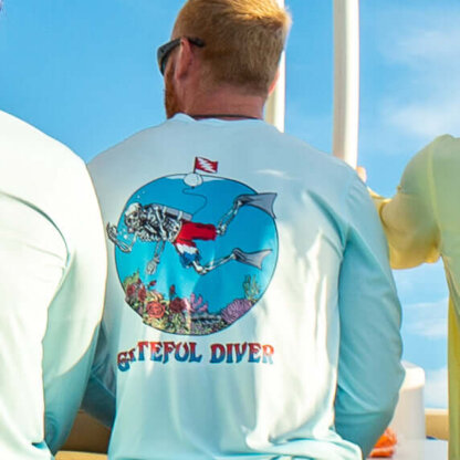 The back of a group of men wearing Grateful Diver Skeleton Diver Short Sleeve UV Shirts on a boat.