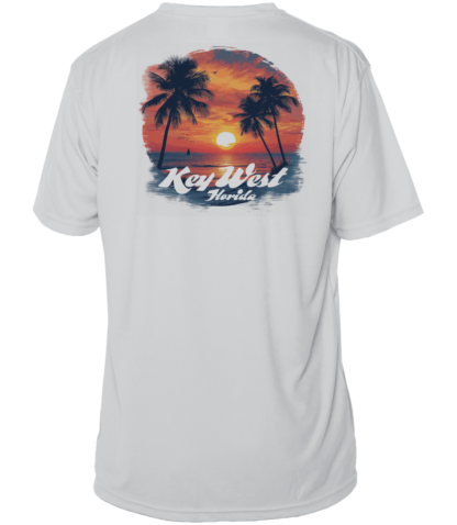 A white swim shirt with palm trees and a sunset, providing sun protective clothing.